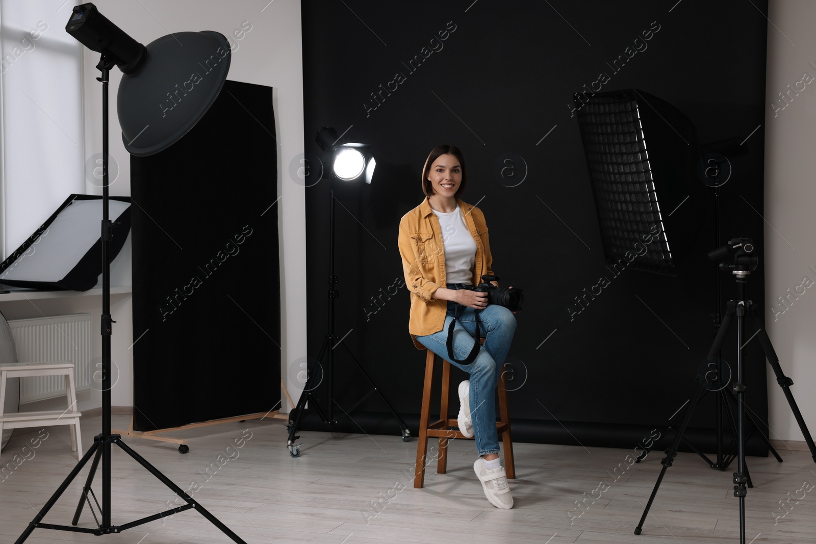 Photo of Professional photographer with camera in modern photo studio