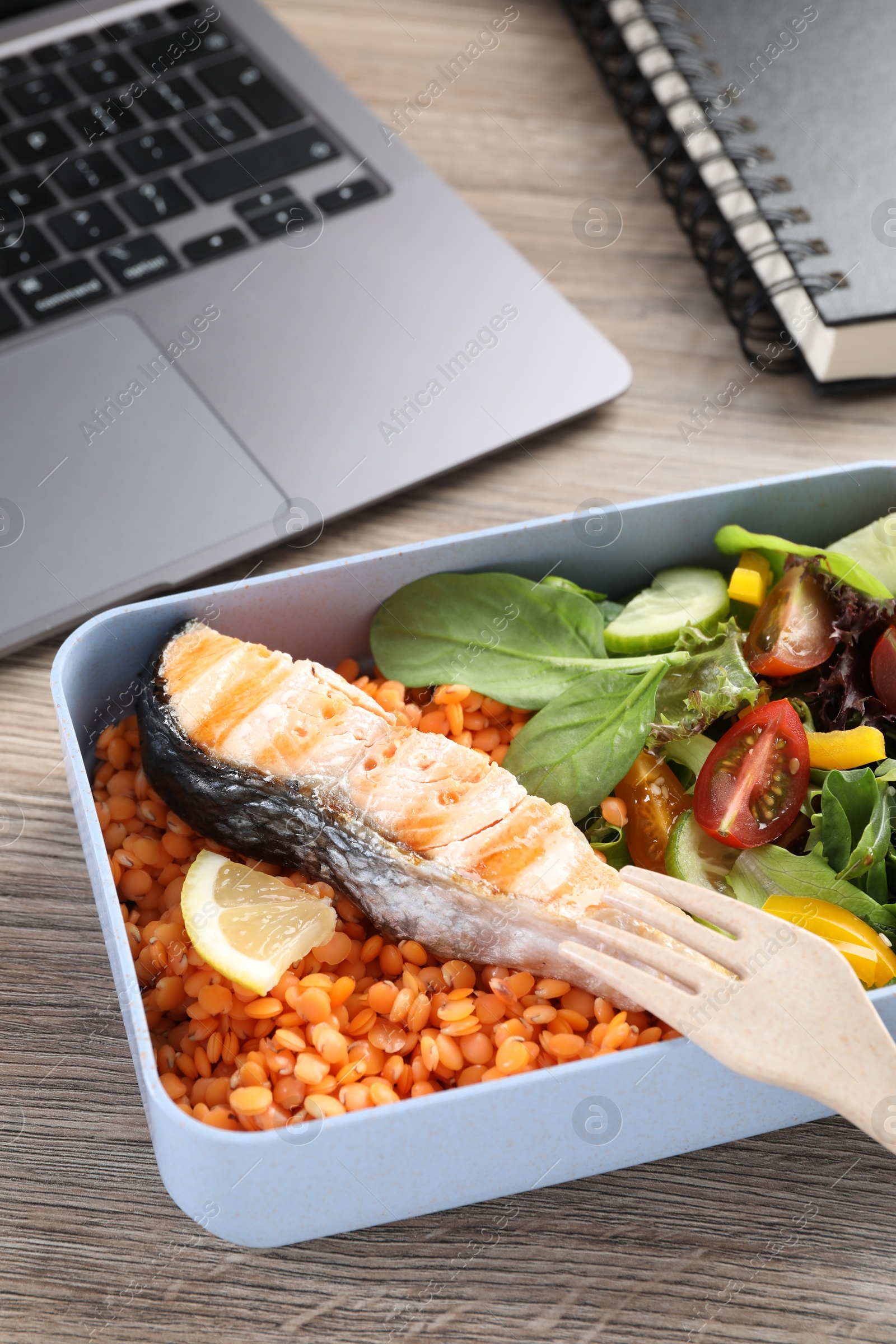 Photo of Healthy products high in vegetable fats near laptop on wooden table, closeup