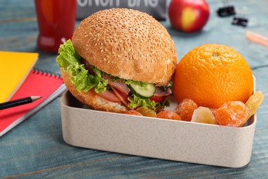 Photo of Lunch box with appetizing food and stationery on table