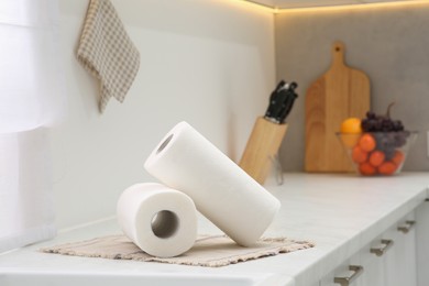 Photo of Rolls of paper towels on white countertop in kitchen. Space for text
