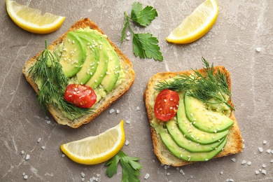 Photo of Tasty crisp toasts with avocado on table, top view