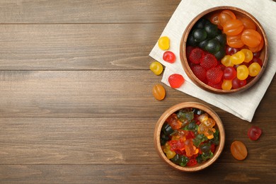 Delicious gummy candies on wooden table, flat lay. Space for text