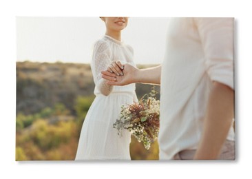 Image of Photo printed on canvas, white background. Happy newlyweds with beautiful bouquet outdoors, closeup