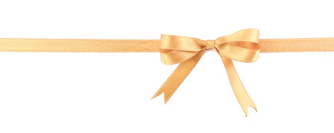 Golden satin ribbon with bow on white background, top view