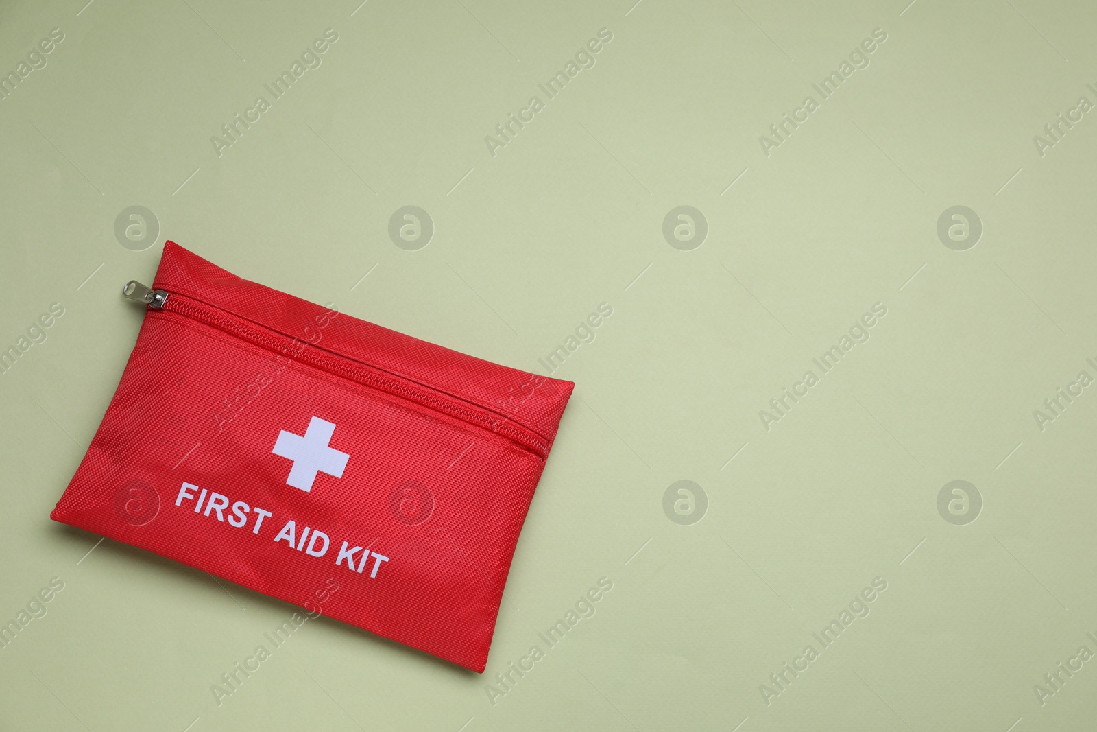 Photo of First aid kit on light green background, top view. Space for text