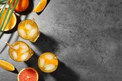 Delicious orange soda water on grey table, flat lay. Space for text