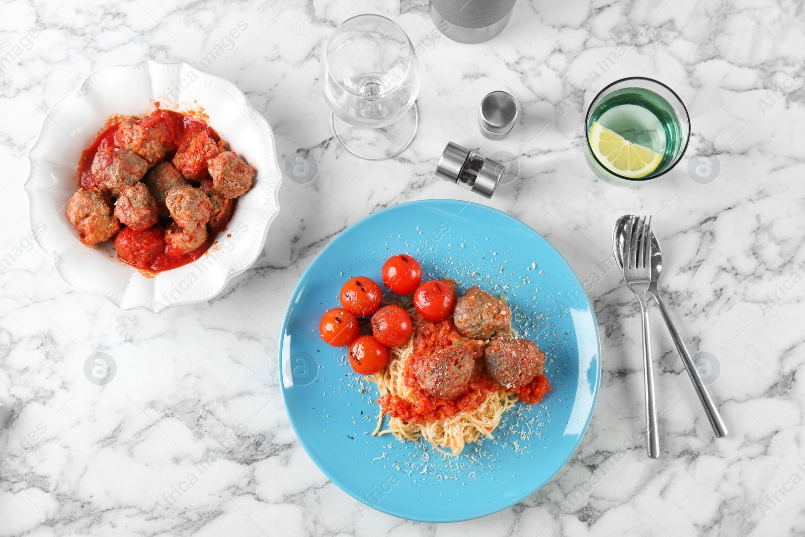 Photo of Delicious pasta with meatballs and tomato sauce on light background, flat lay