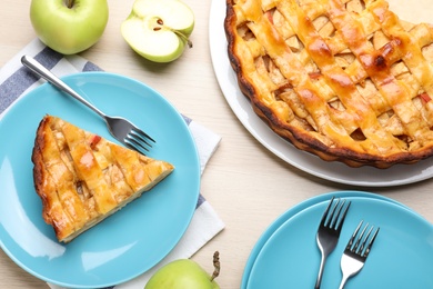 Photo of Traditional apple pie and fresh fruits on wooden table, flat lay