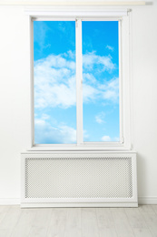 Image of Beautiful view on blue sky with clouds through window in room