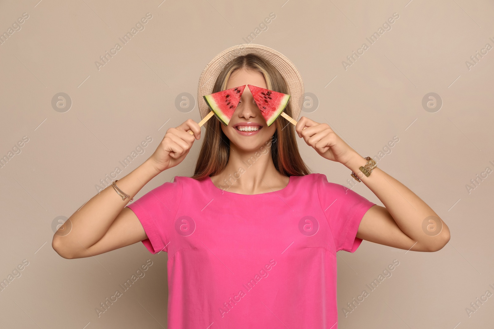 Photo of Beautiful girl with pieces of watermelon on beige background