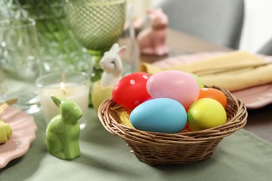 Photo of Festive Easter table setting with painted eggs, closeup