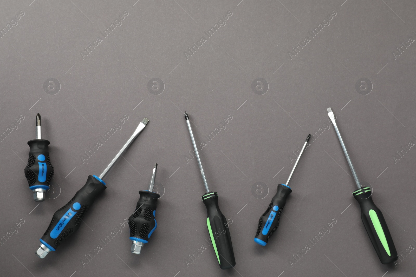 Photo of Set of screwdrivers on grey background, flat lay. Space for text