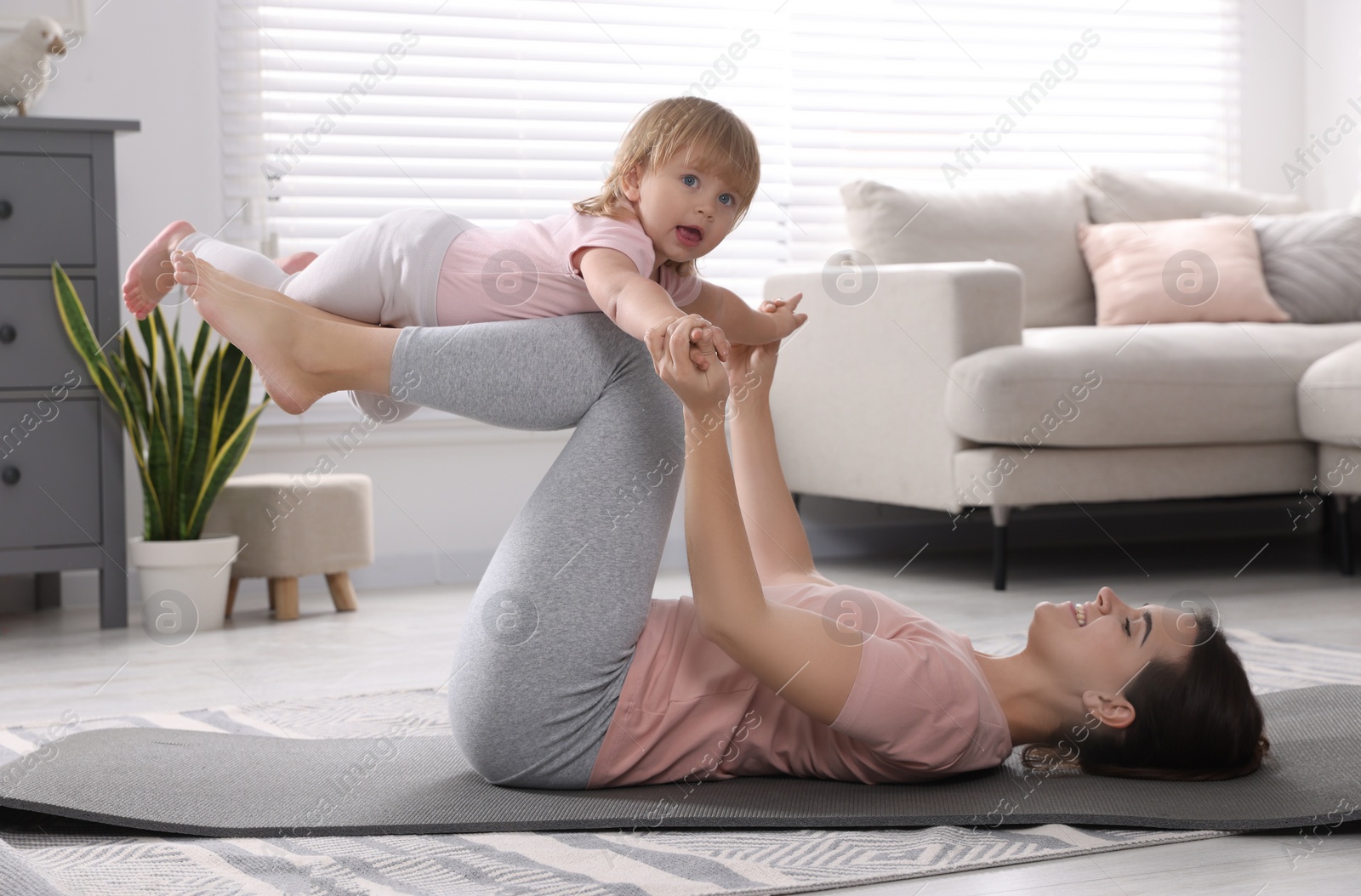 Photo of Mother doing exercise with her daughter at home