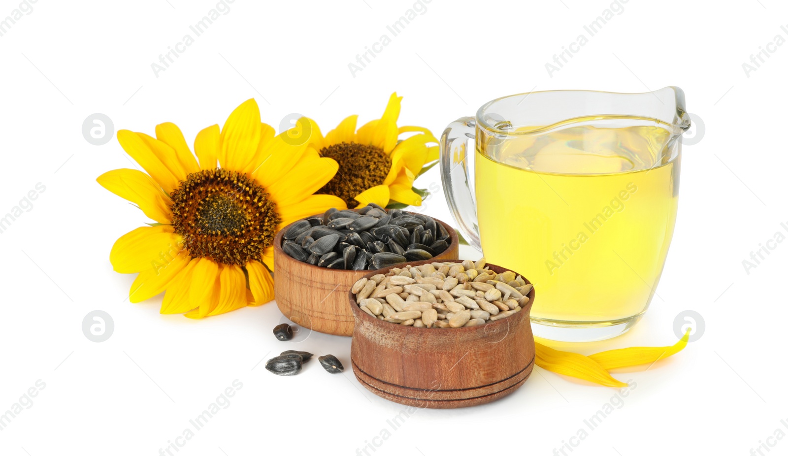 Photo of Sunflowers, jug of oil and seeds on white background