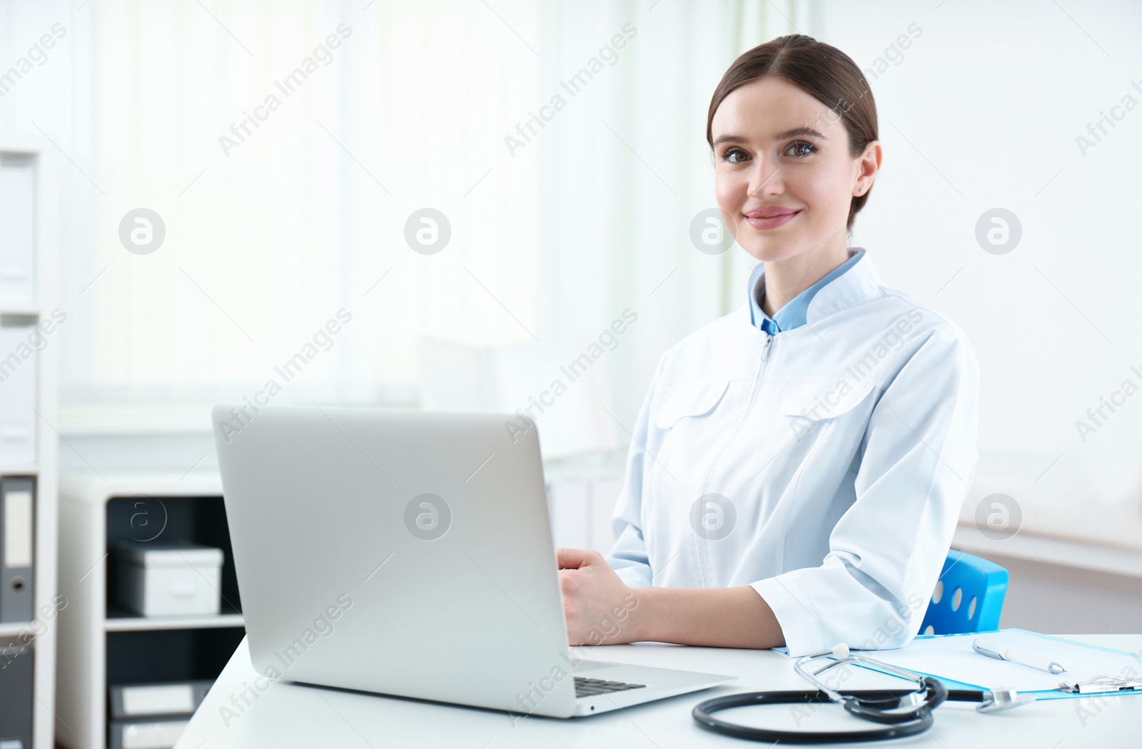 Photo of Portrait of young female doctor in white coat at workplace