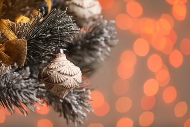 Photo of Vintage holiday bauble hanging on Christmas tree against blurred festive lights, closeup. Space for text