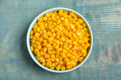 Photo of Tasty canned sweet corn on blue wooden table, top view