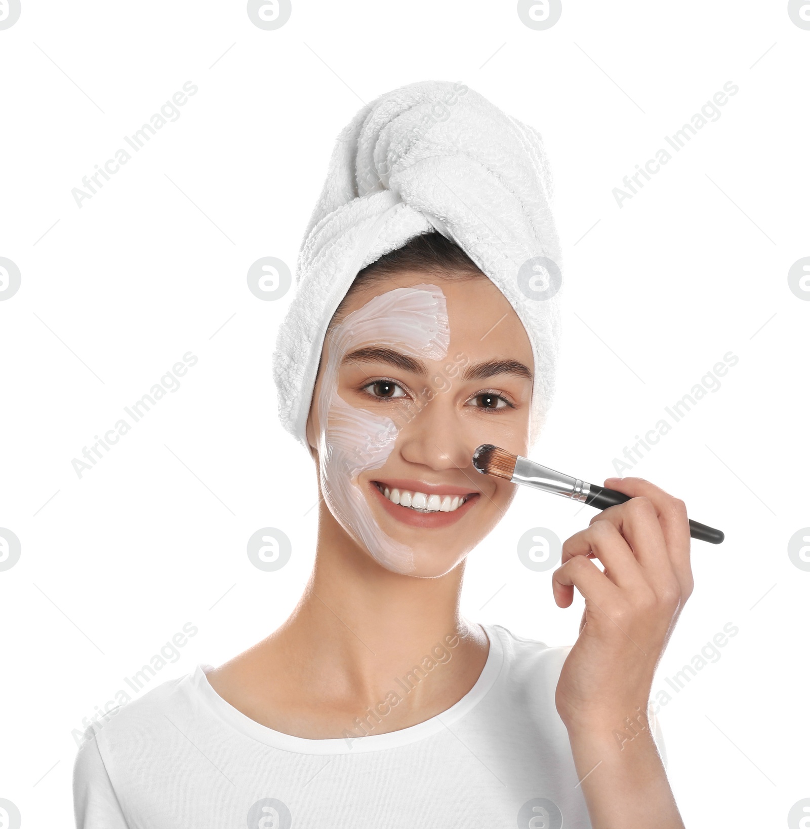 Photo of Happy young woman applying organic mask on her face against white background