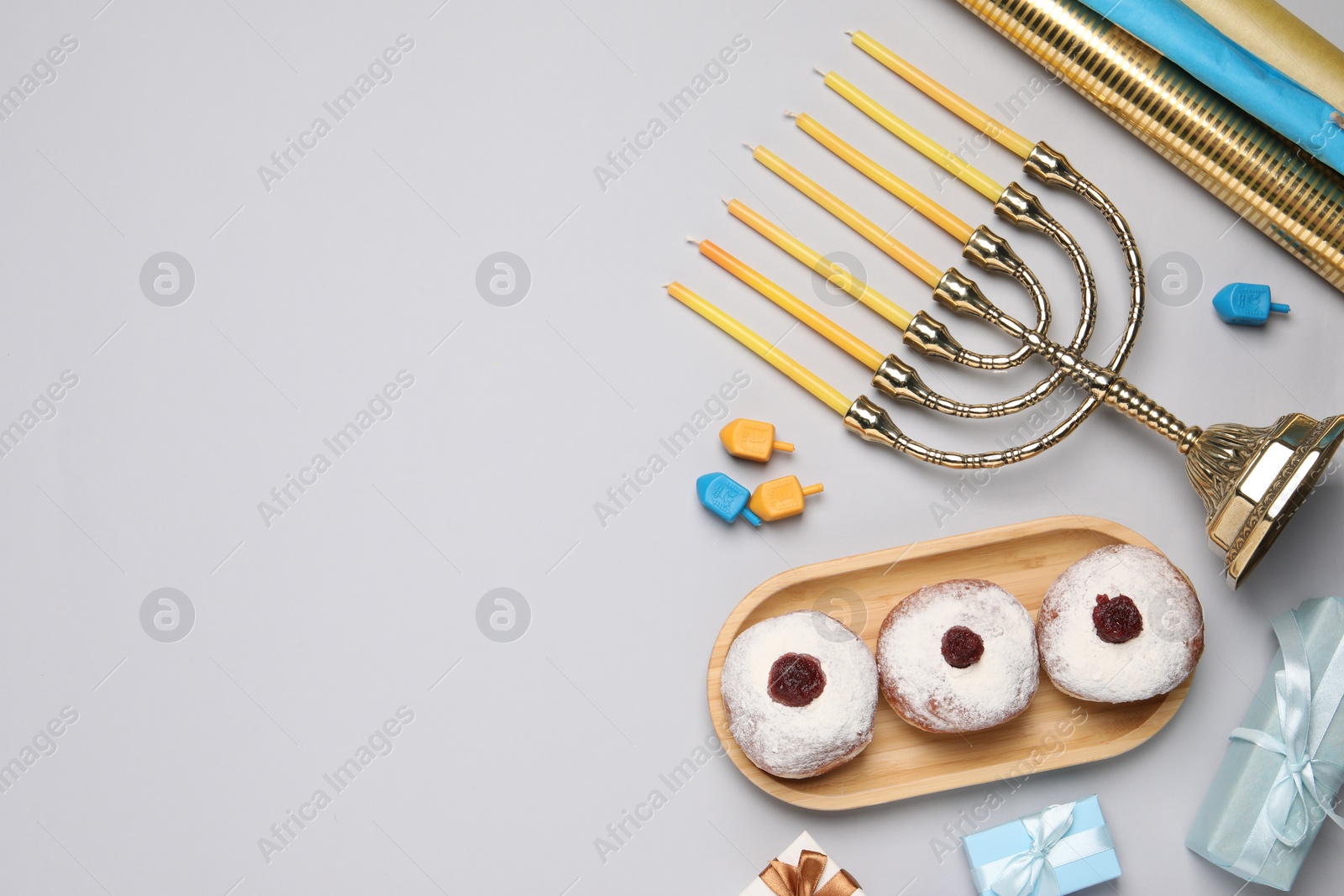 Photo of Flat lay composition with Hanukkah menorah and gift boxes on light grey background. Space for text