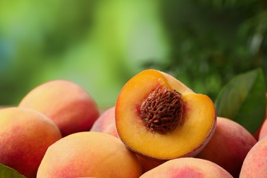 Photo of Cut and whole fresh ripe peaches against blurred background, closeup. Space for text
