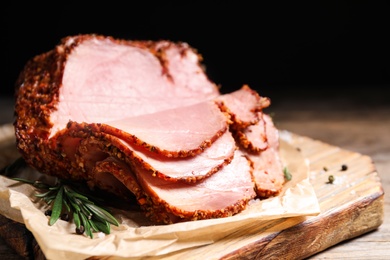 Delicious ham on wooden table against black background. Christmas dinner