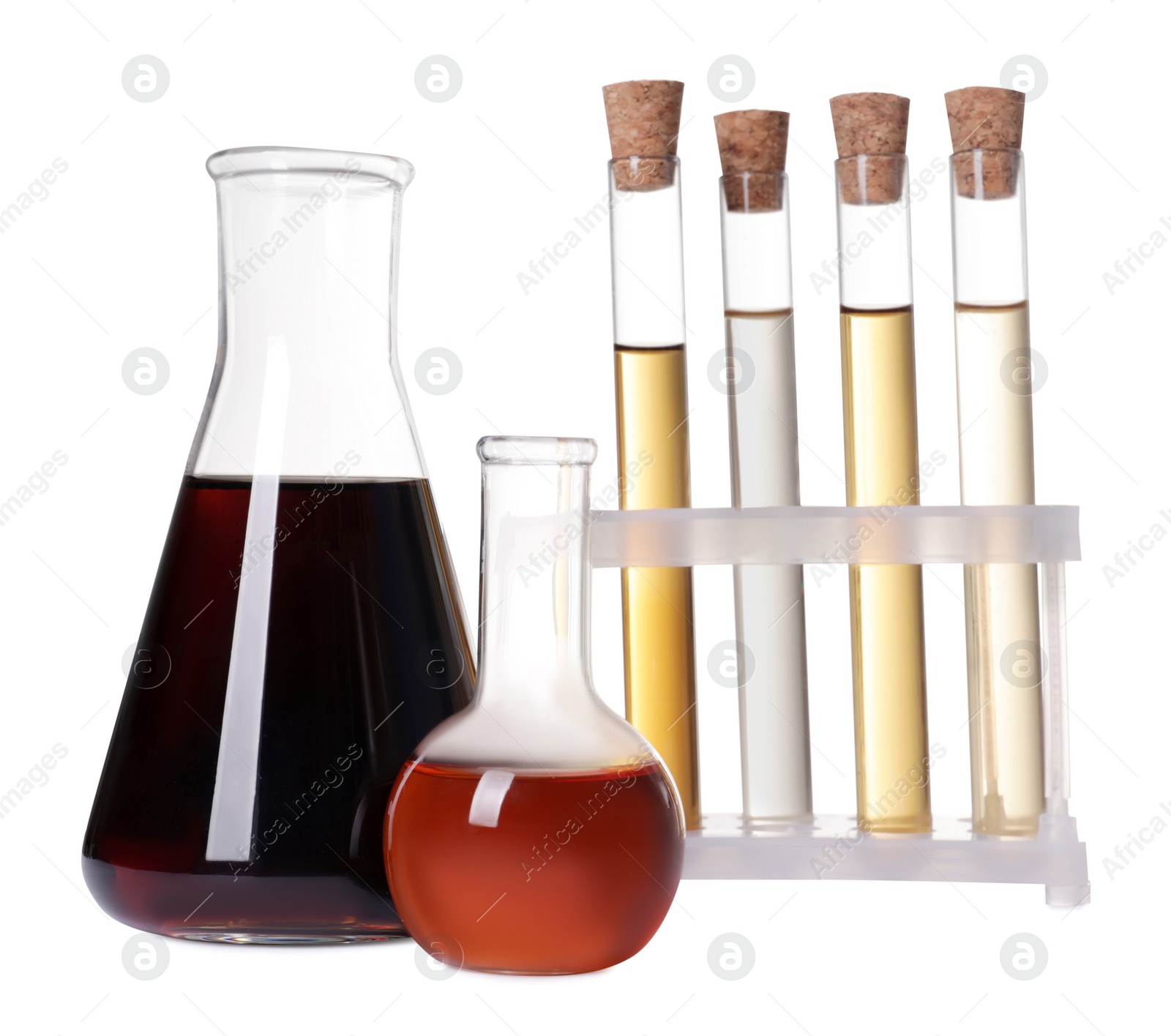 Photo of Different laboratory glassware with brown liquids on white background