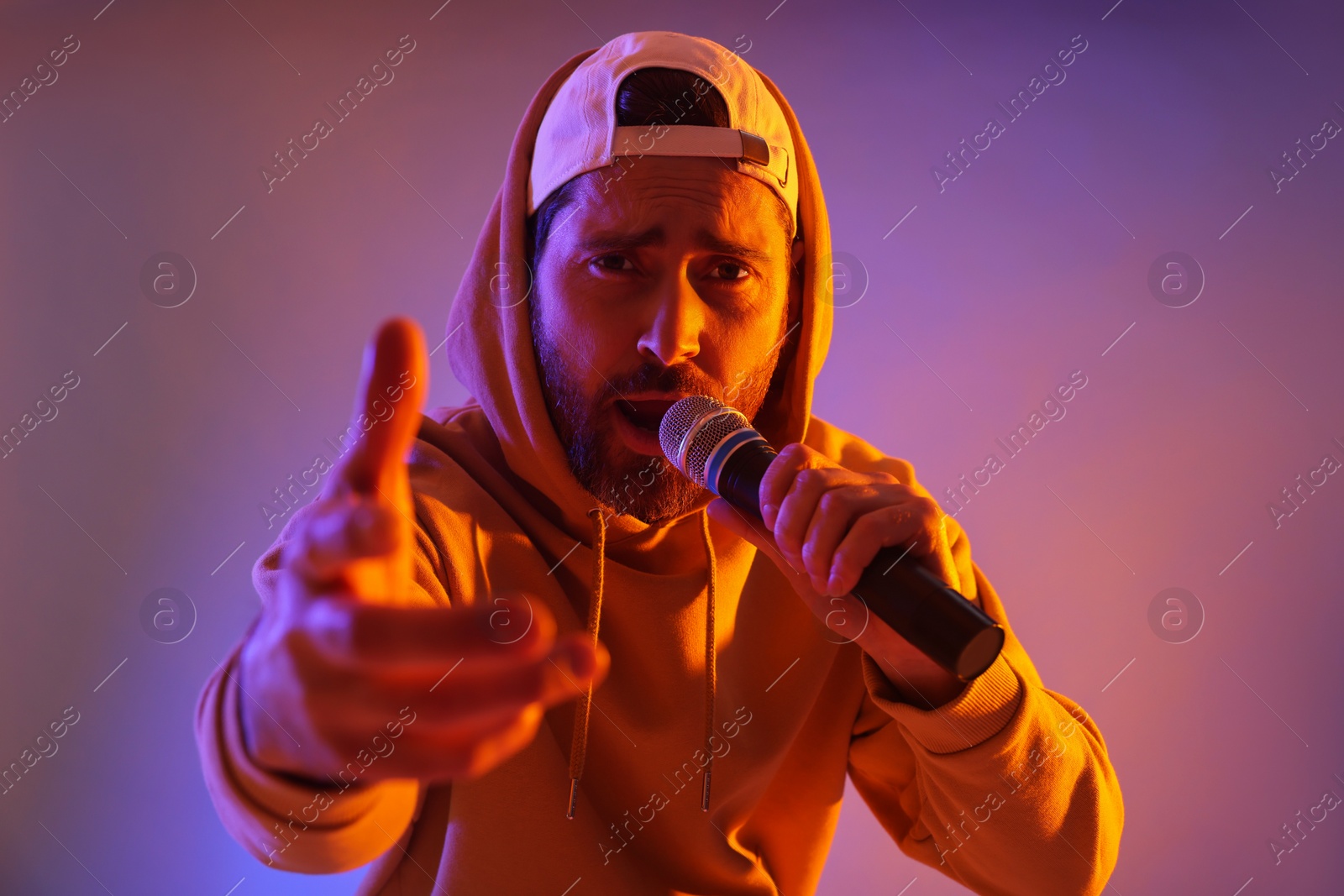 Photo of Singer with microphone rapping in color lights