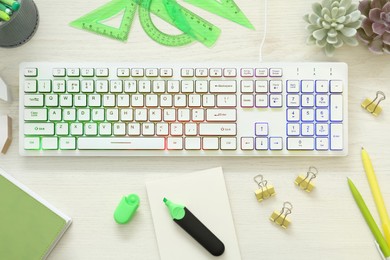 Flat lay composition with modern RGB keyboard on white wooden table