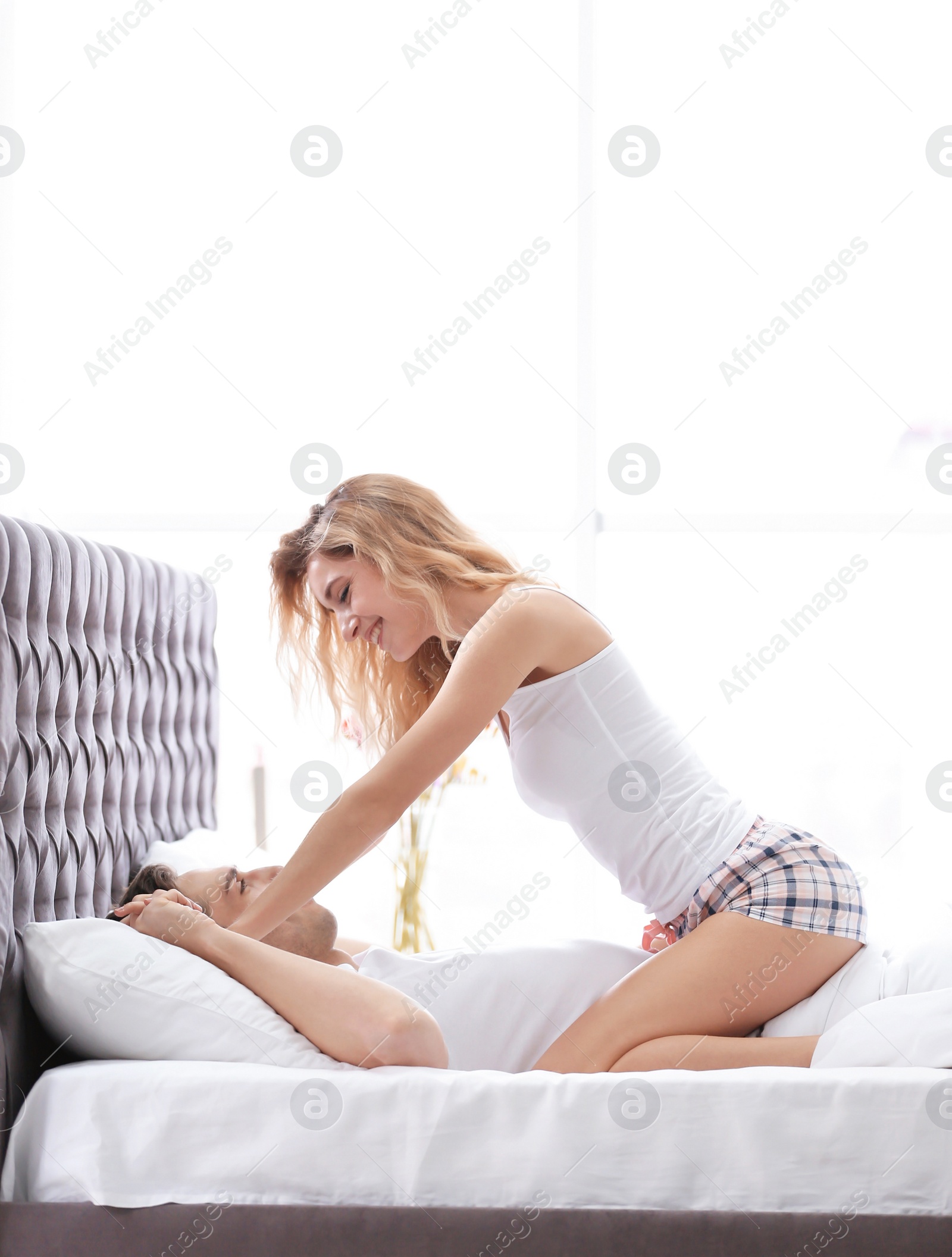 Photo of Happy young couple being intimate at home