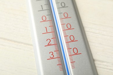 Modern weather thermometer on white wooden background, closeup