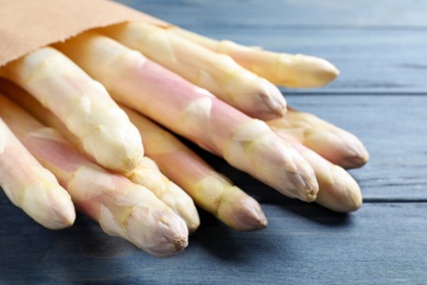 Photo of Fresh white asparagus on blue wooden table, closeup