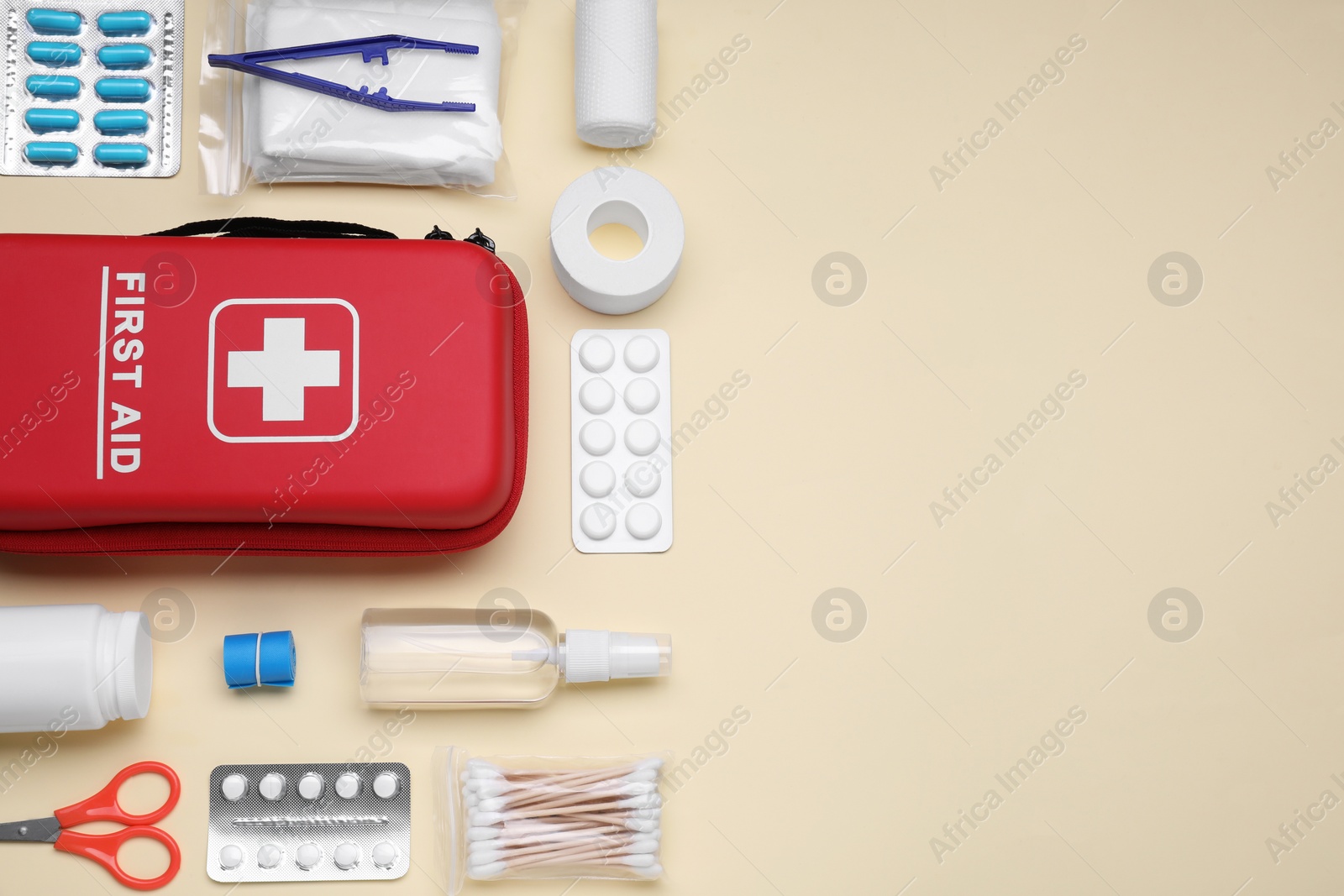 Photo of Flat lay composition with first aid kit on beige background. Space for text