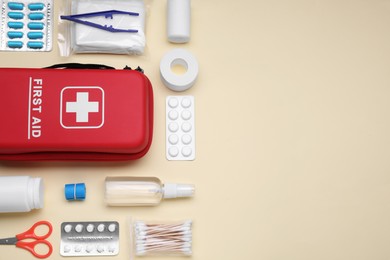 Flat lay composition with first aid kit on beige background. Space for text