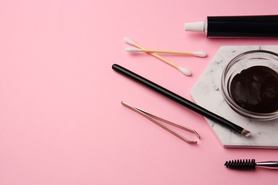 Photo of Eyebrow henna and tools on pink background. Space for text