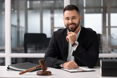 Photo of Portrait of smiling lawyer at table in office