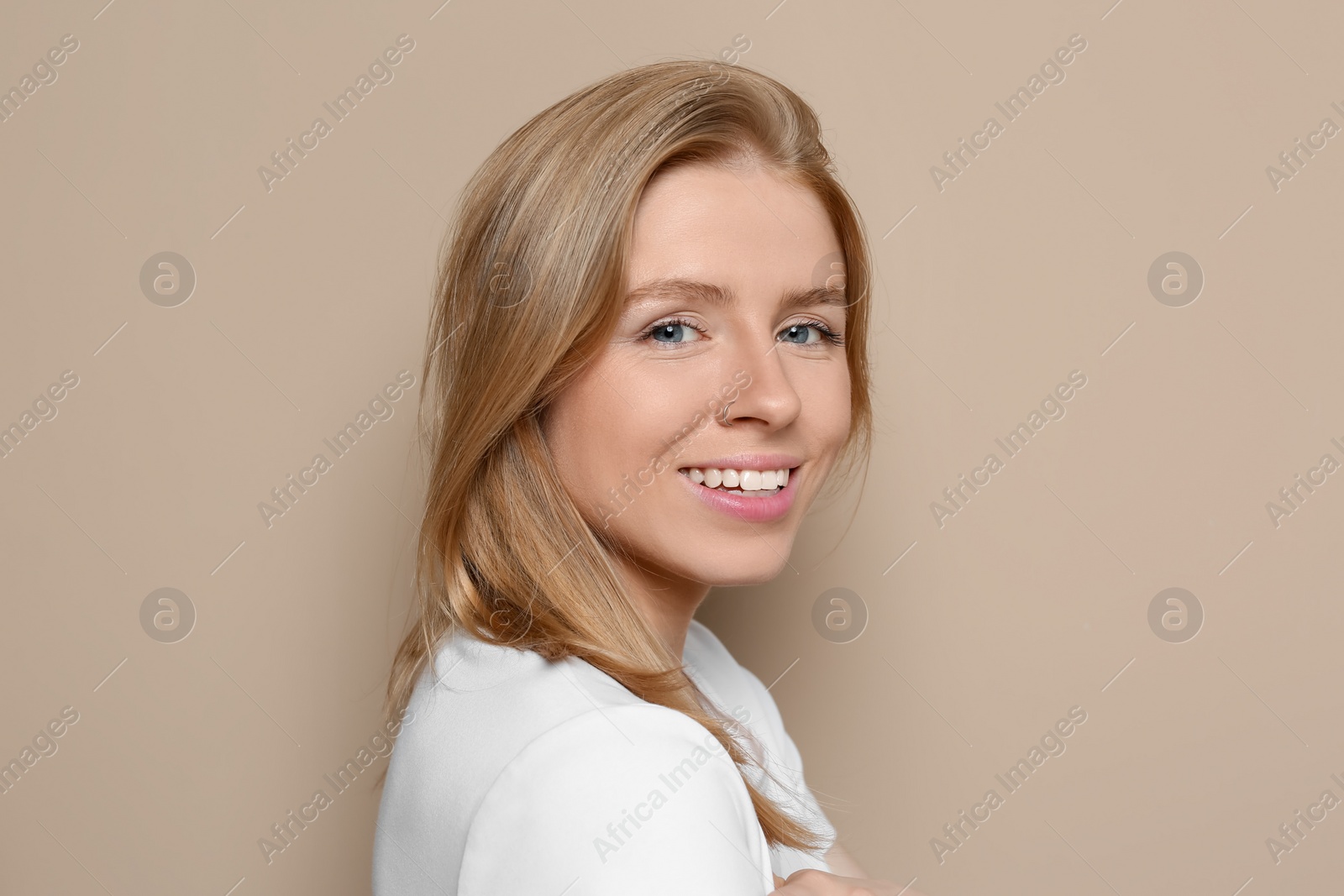 Photo of Portrait of beautiful young woman on beige background