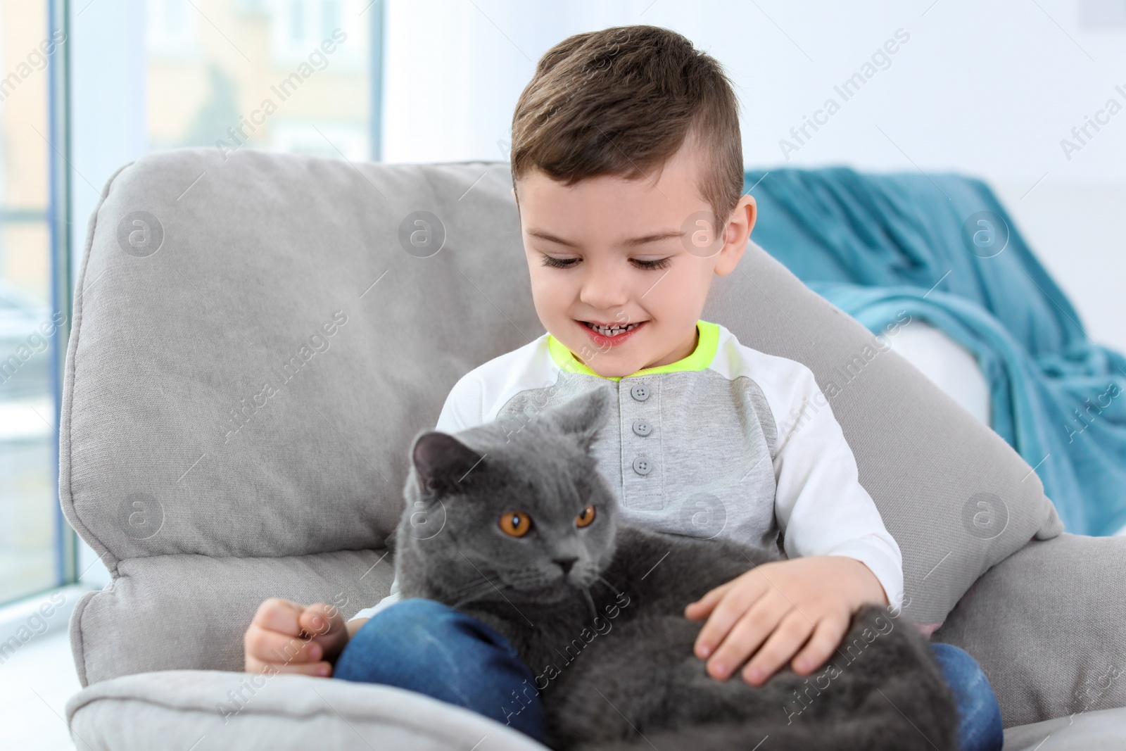 Photo of Cute little child with cat at home