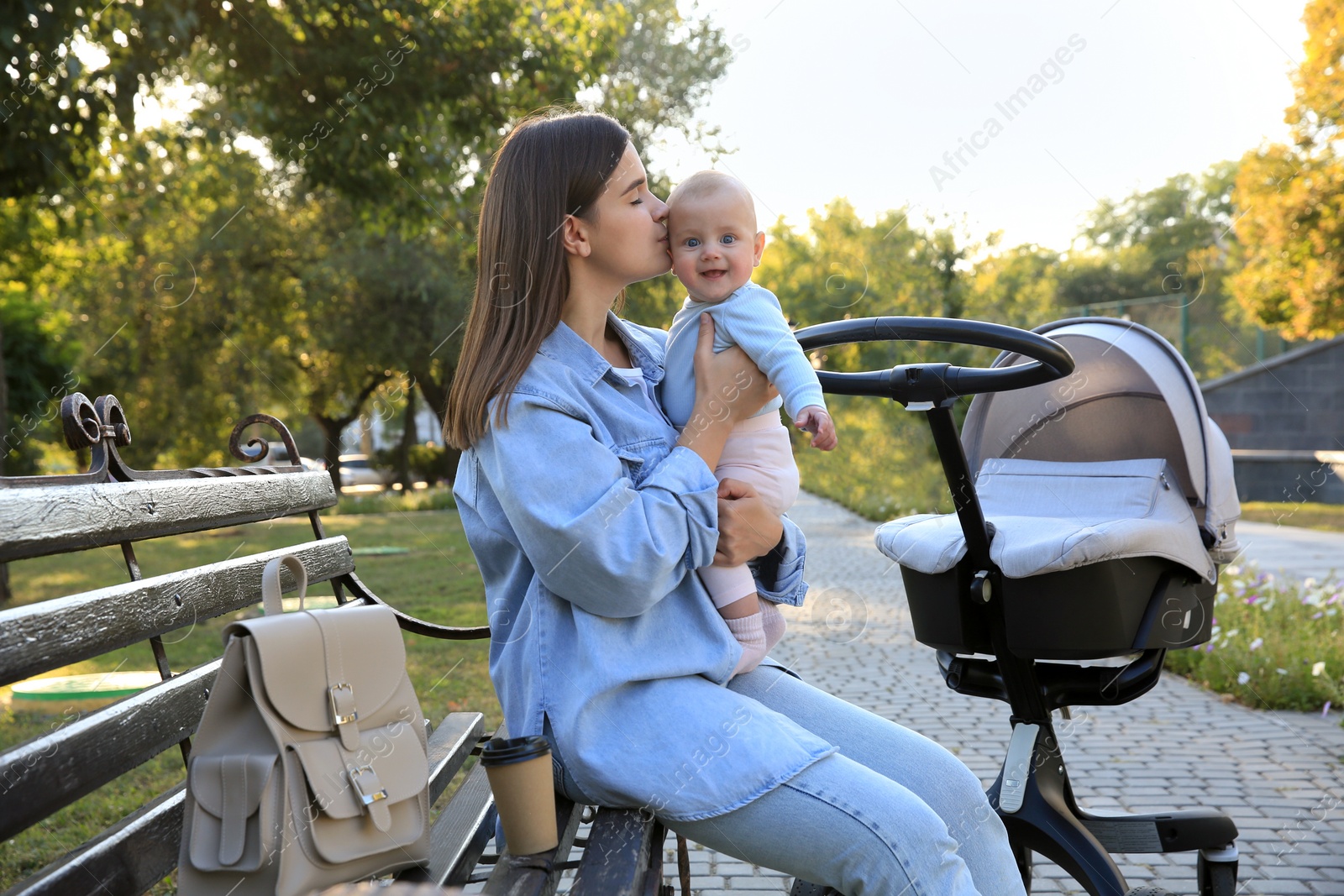 Photo of Young mother with her baby on bench in park