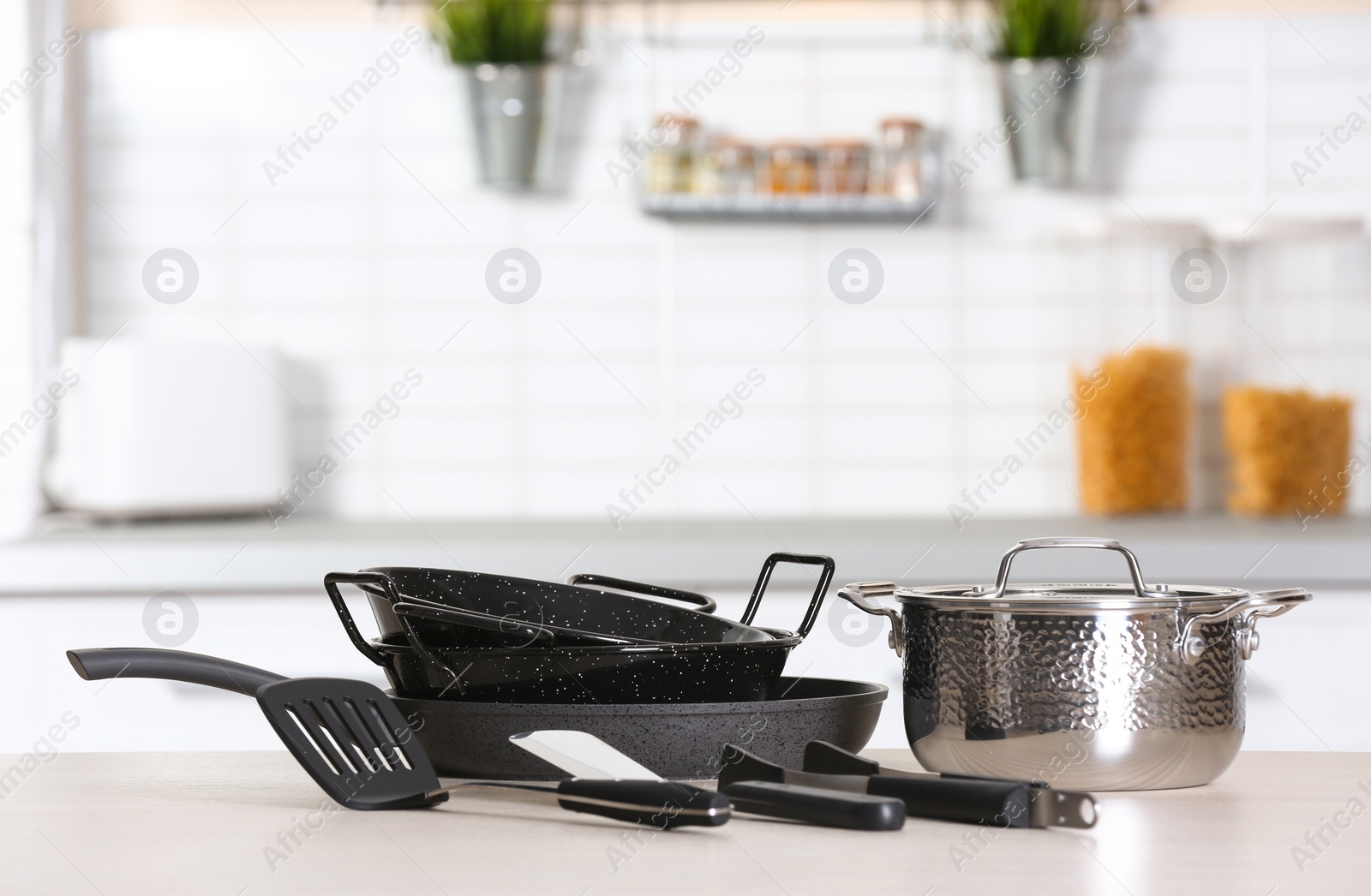 Photo of Set of clean cookware and utensils on table in kitchen. Space for text