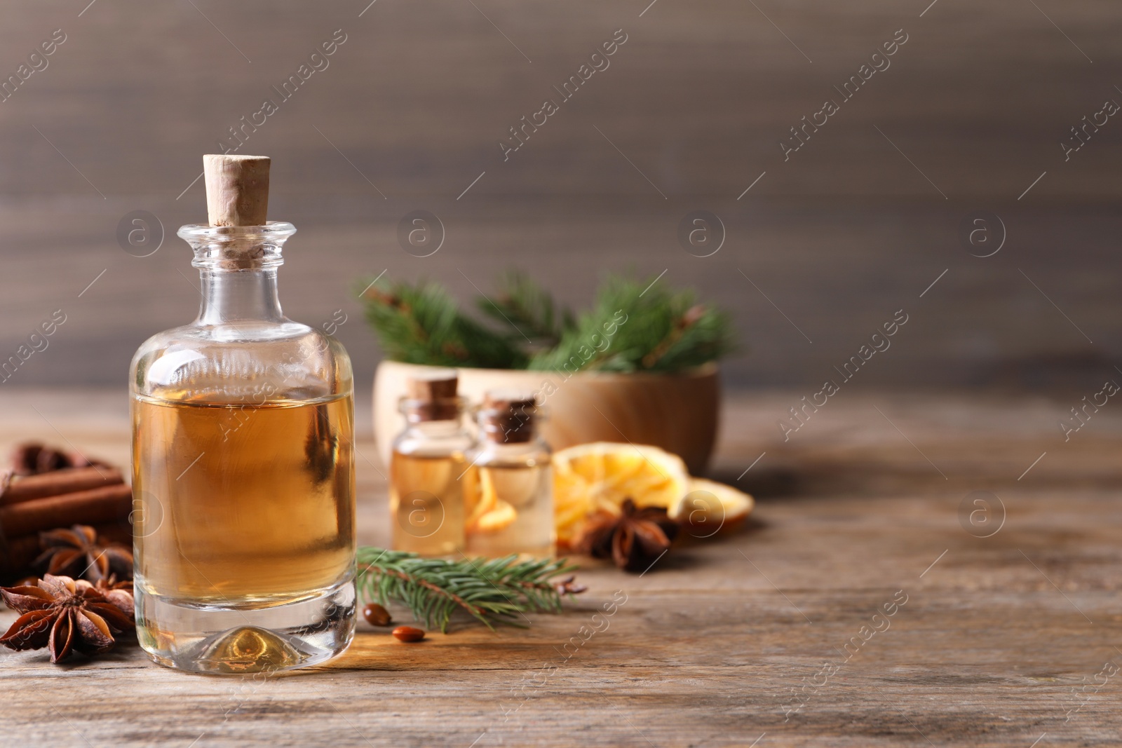 Photo of Anise essential oil and spices on wooden table, space for text