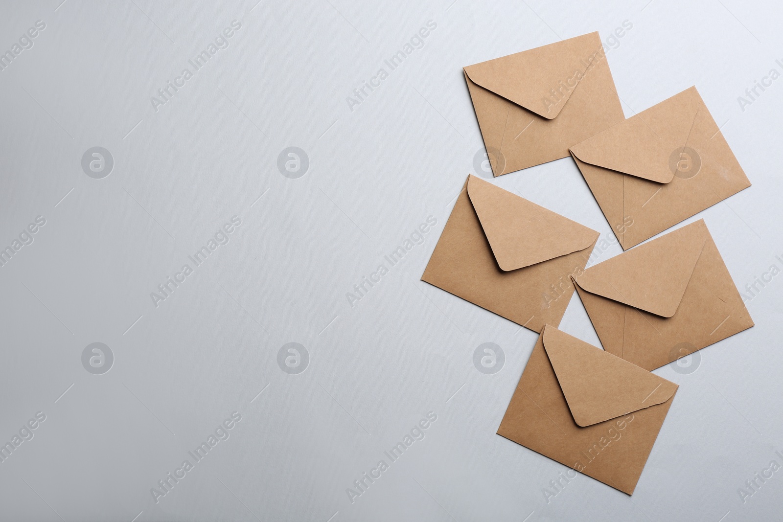 Photo of Brown paper envelopes on light background, flat lay. Space for text