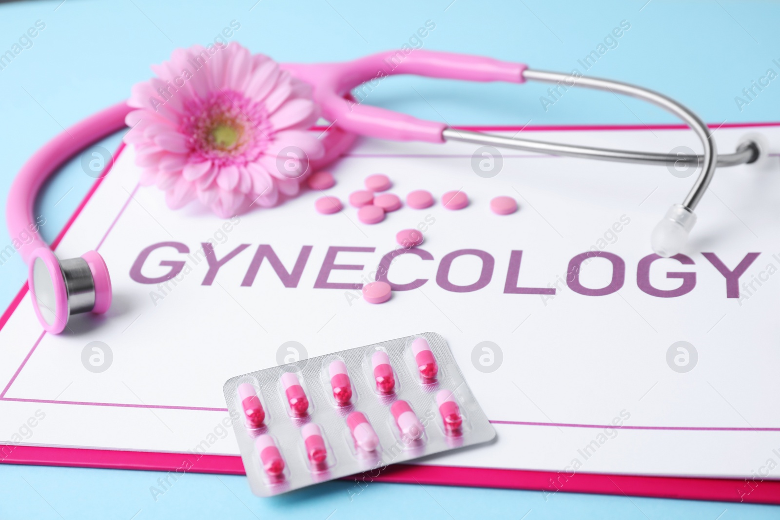 Photo of Composition with pills and clipboard on blue background. Gynecology concept