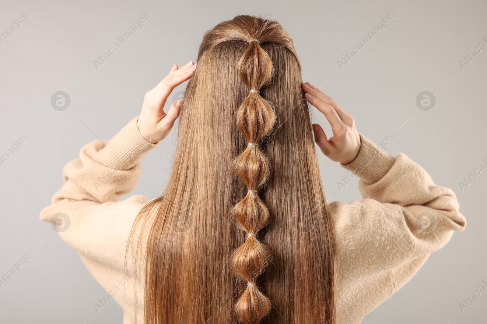 Photo of Woman with braided hair on grey background, back view