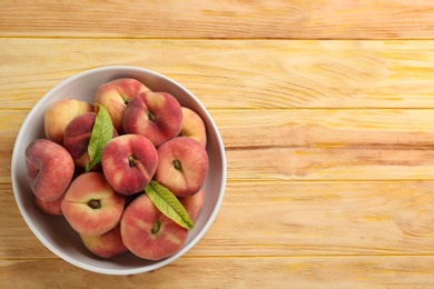 Fresh ripe donut peaches on wooden table, top view. Space for text