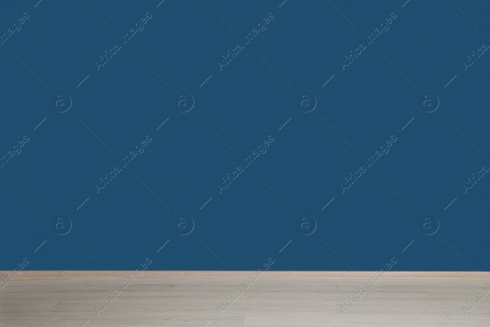 Photo of Beautiful light blue wall and wooden floor in clean empty room