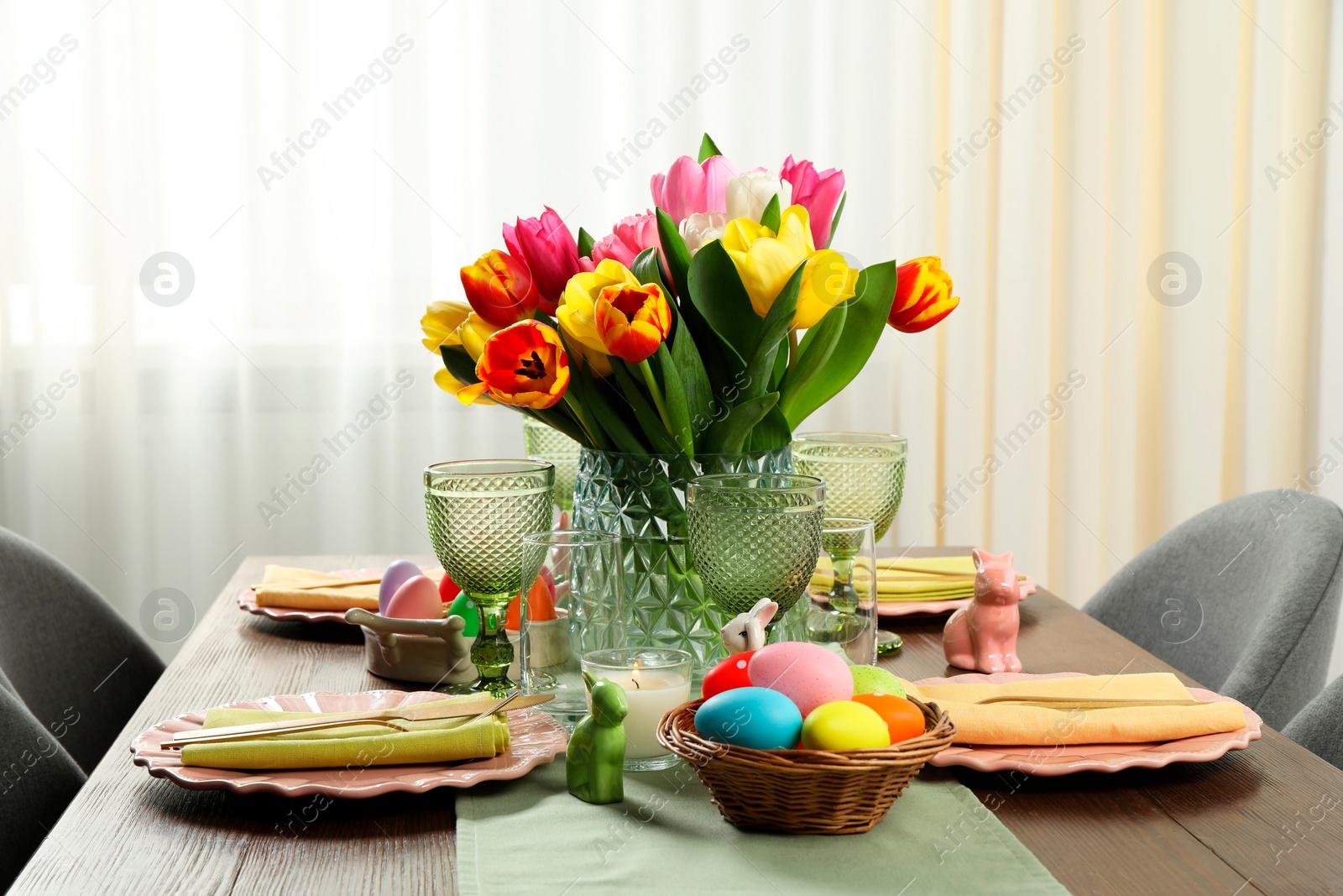 Photo of Easter celebration. Festive table setting with beautiful flowers and painted eggs