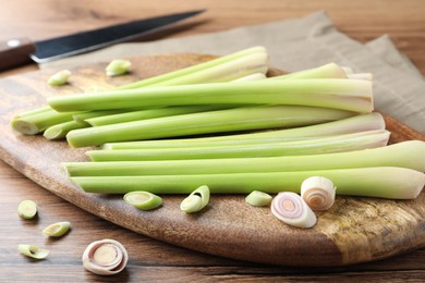 Board with fresh lemongrass stalks on wooden table, closeup