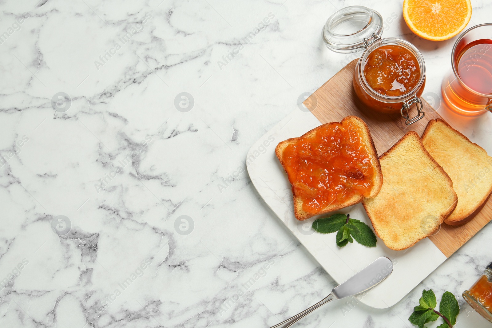 Photo of Delicious toasts served with jam, tea and mint on white marble table, flat lay. Space for text