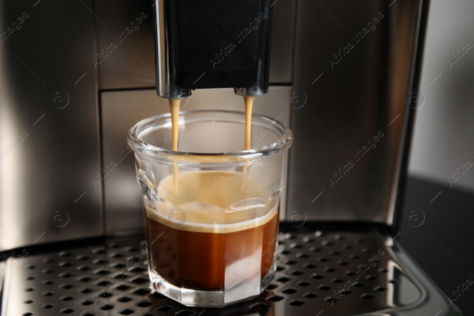 Photo of Espresso machine pouring coffee into glass, closeup