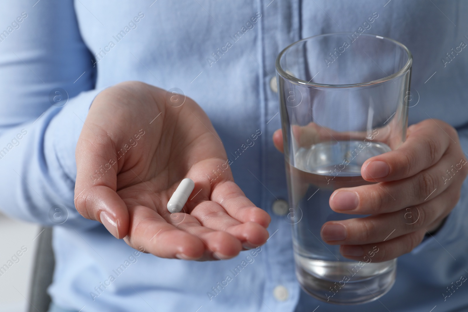 Photo of Woman with glass of water and pill, closeup